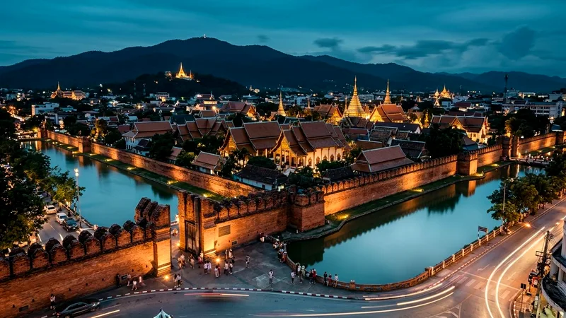 Chiang Mai old town moat, Tha Phae Gate and temple rooftops at dusk