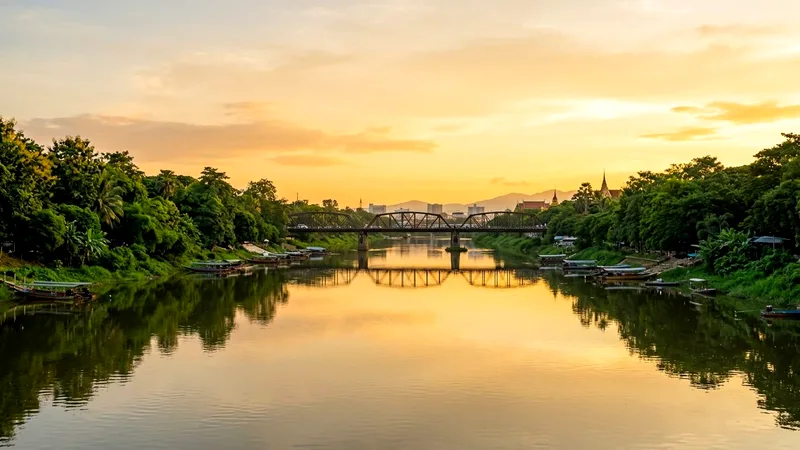 Mae Ping River at golden hour with the Iron Bridge in the distance